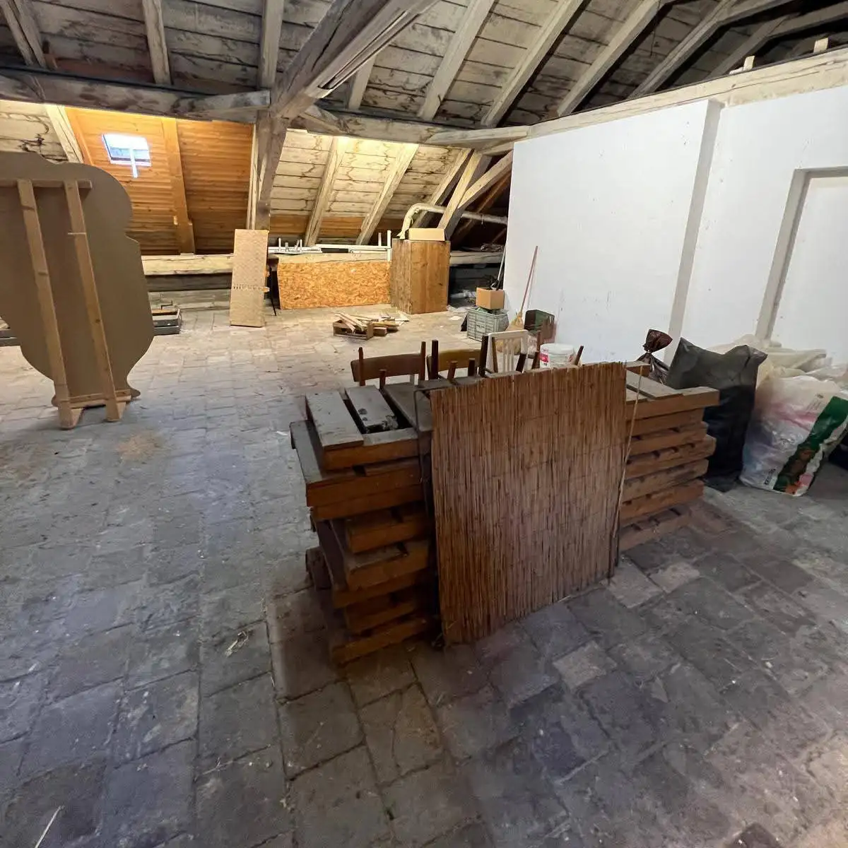 Dachbodenentrümpelung Wien – Dachboden mit Möbeln und Holzmaterial vor der Räumung