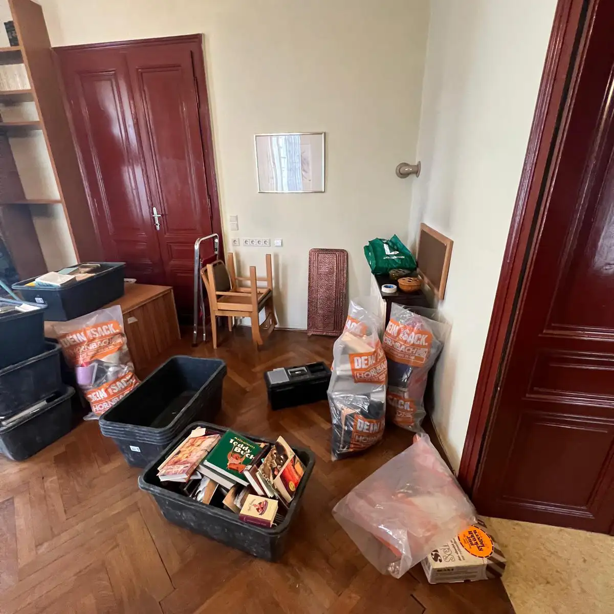 Entrümpelung Wien – Zimmer mit Kisten, Büchern und Haushaltsgegenständen vor der Entrümpelung