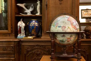 Antiquitäten Ankauf: Antiker Globus, Cloisonné Vase, Porzellanfiguren in geschnitztem Biedermeier Möbel