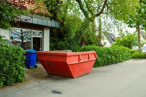 Rote Absetzmulde steht auf privater Einfahrt vor Einfamilienhaus in Wien, Container mieten ohne MA 46 Genehmigung