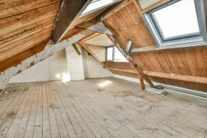 Wiener Altbau-Dachboden mit Holzbalken und Dachfenstern vor dem Ausbau