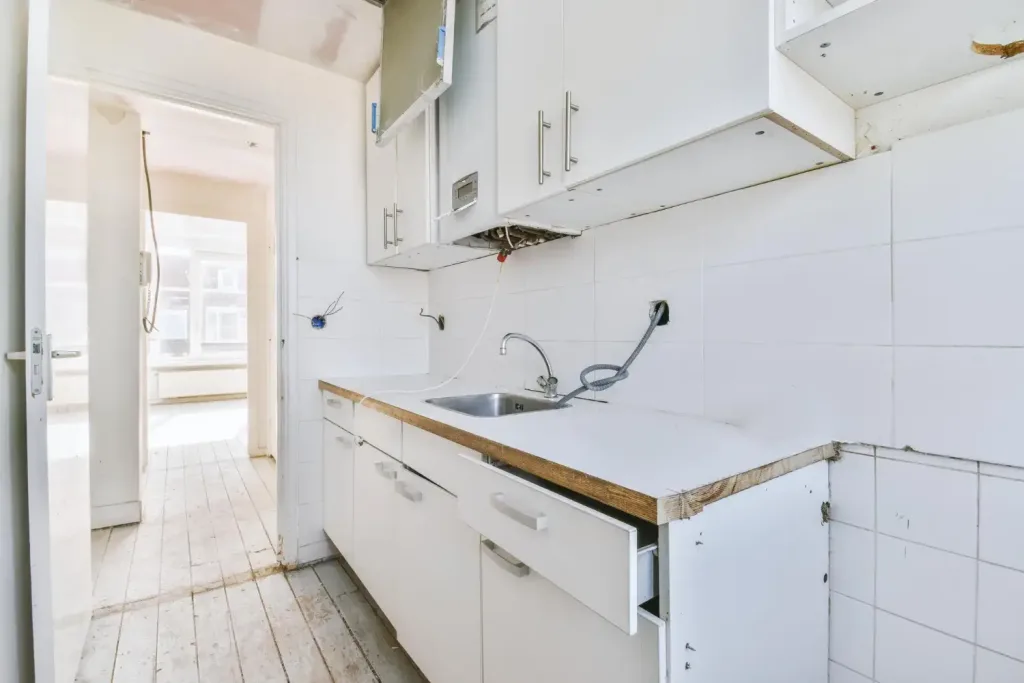 Einbauküche entsorgen Wien – alte Linearküche mit geöffneter Schublade und freigelegten Anschlüssen nach Demontage