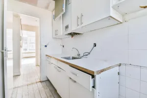 Einbauküche entsorgen Wien – alte Linearküche mit geöffneter Schublade und freigelegten Anschlüssen nach Demontage