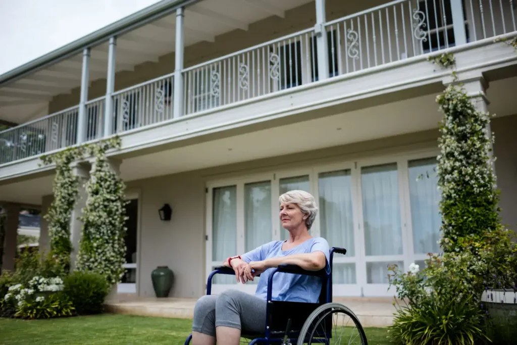 Seniorin im Rollstuhl vor ihrem Zuhause vor dem Einzug ins Pflegeheim Wien
